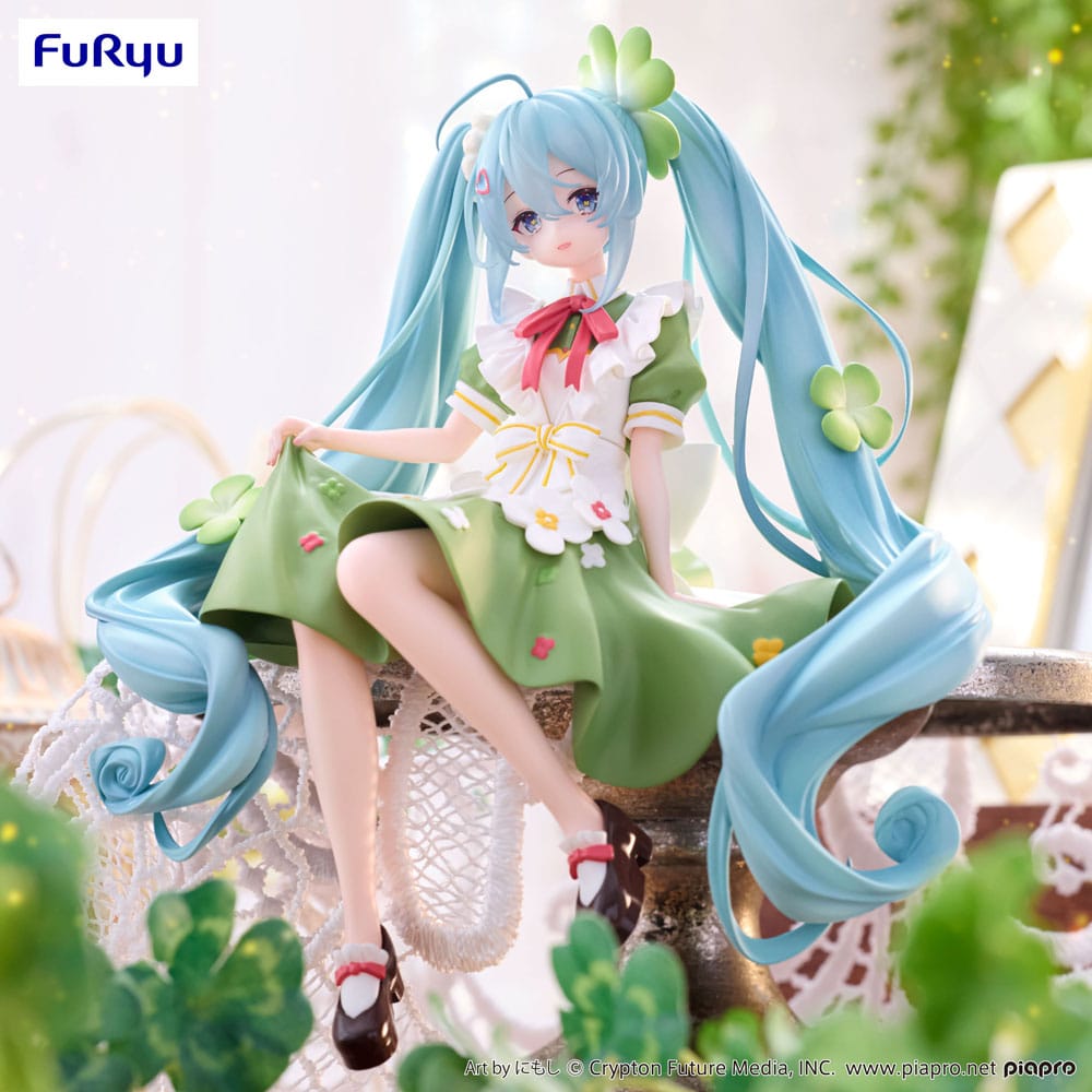 Figurine Hatsune Miku Flower Fairy Clover de 15 cm, assise en tenue verte décorée de trèfles et de fleurs, avec de longues couettes bleu clair et un ruban rouge.
