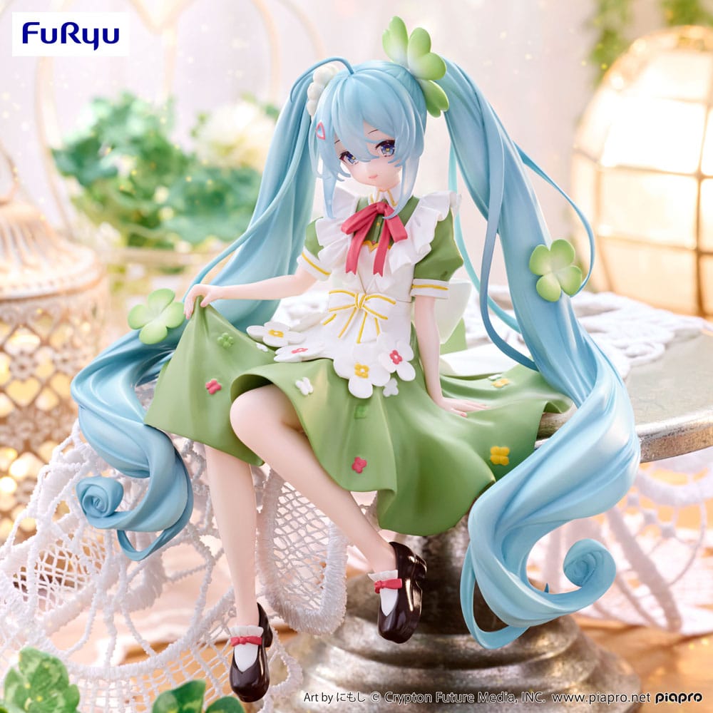 Figurine Hatsune Miku Flower Fairy Clover de 15 cm, assise en tenue verte décorée de trèfles et de fleurs, avec de longues couettes bleu clair et un ruban rouge.