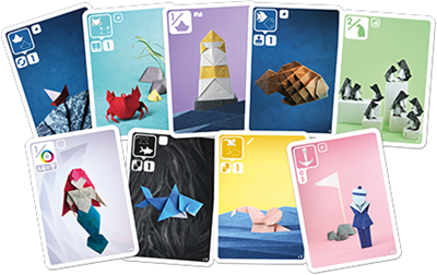 Boîte du jeu Sea Salt & Paper avec vague en origami bleu et blanc et petit bateau en papier rouge sur fond bleu.