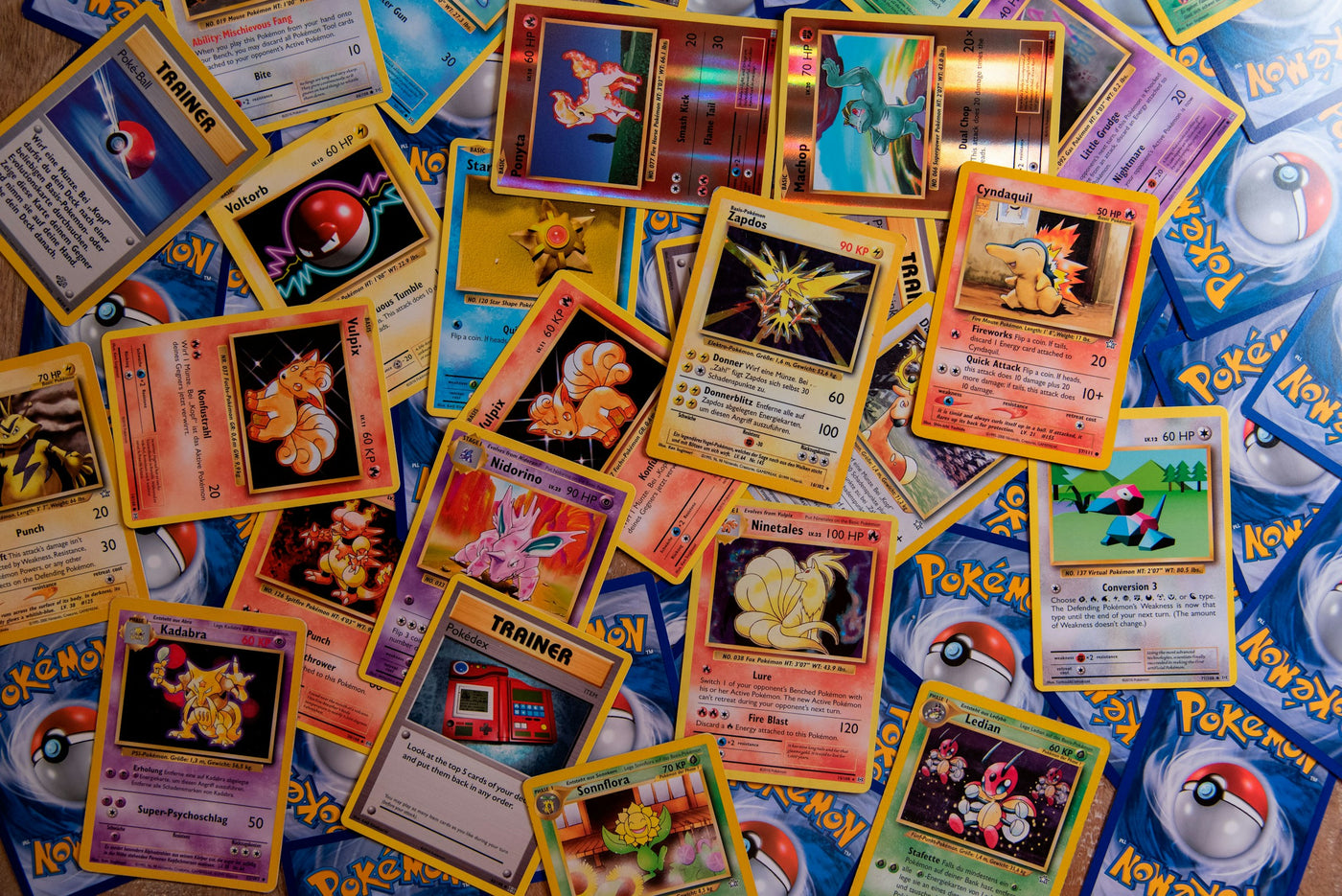 Cartes Pokémon vintage dispersées en éventail, illustrant la collection TCG disponible sur le site Dojo & Dragons, spécialisé en cartes Pokémon, Yu-Gi-Oh!, One Piece Card Game, Magic: The Gathering et accessoires pour joueurs.