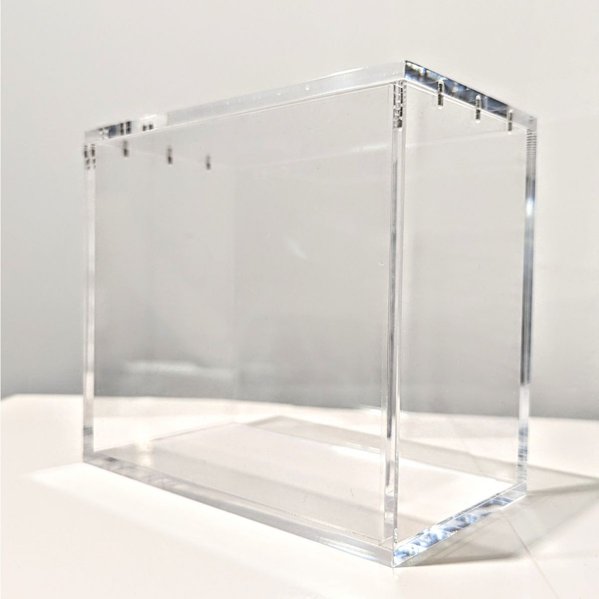 Boîte de protection en plexiglass transparent avec couvercle aimanté pour boosters et cartes de collection.
