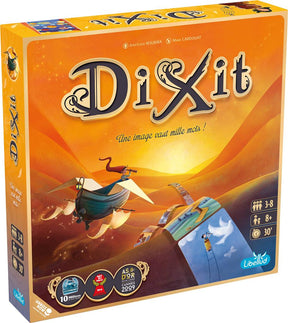 Boîte du jeu Dixit avec paysage orange, bateau volant et cartes illustrées dans un univers poétique.