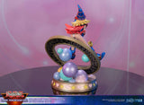 Figurine de Dark Magician Girl en PVC, posée dans un cercle magique décoré de runes, avec des sphères pastel à la base. Elle porte sa tenue bleue et rose emblématique, avec un chapeau pointu et une pose dynamique.