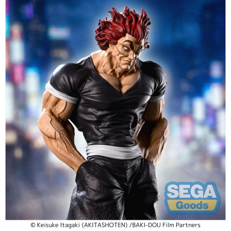 Figurine Baki Luminasta Yujiro Hanma par Sega, représentant Yujiro en tenue noire, mains dans les poches, cheveux rouges et posture menaçante sur un socle urbain.