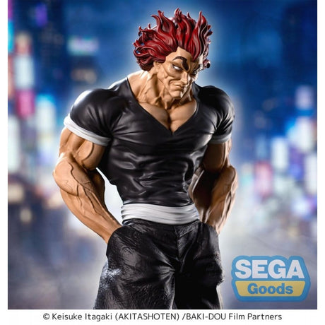 Figurine Baki Luminasta Yujiro Hanma par Sega, représentant Yujiro en tenue noire, mains dans les poches, cheveux rouges et posture menaçante sur un socle urbain.