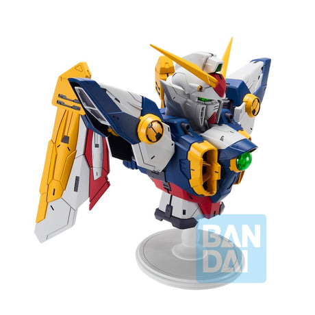 Figurine Bandai Ichibansho Wing Gundam 30th Anniversary sur socle, avec armure blanche, bleue, rouge et jaune et ailes mécaniques.