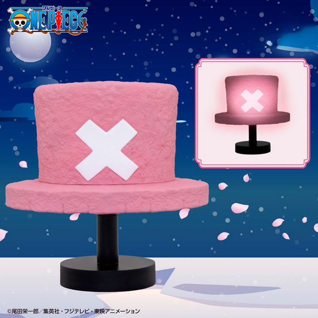 Lampe décorative One Piece Hat Room Light Chopper en forme de chapeau rose avec croix blanche sur socle noir.